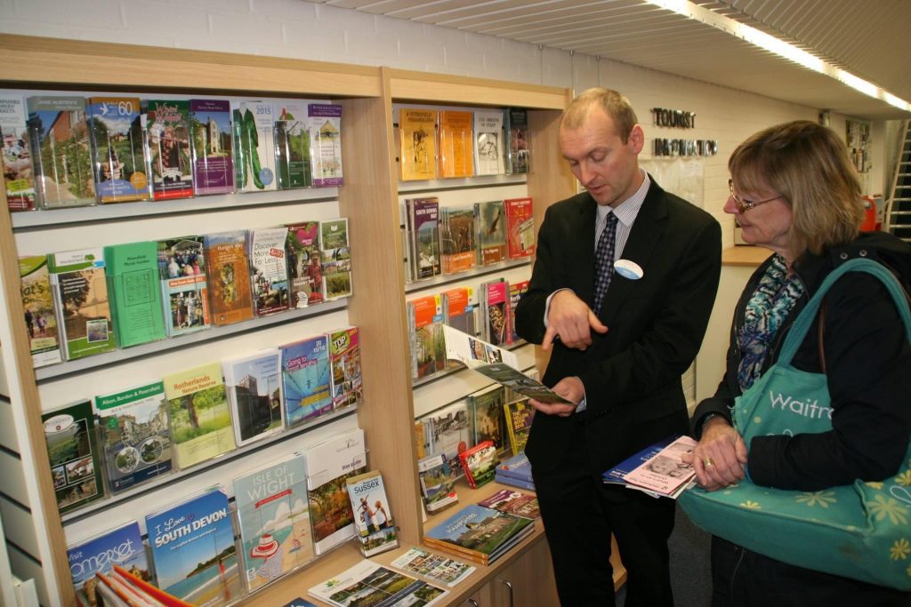 tourist centre manager assisting a member of the public